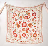 Floral patterned scarf held up against a white background