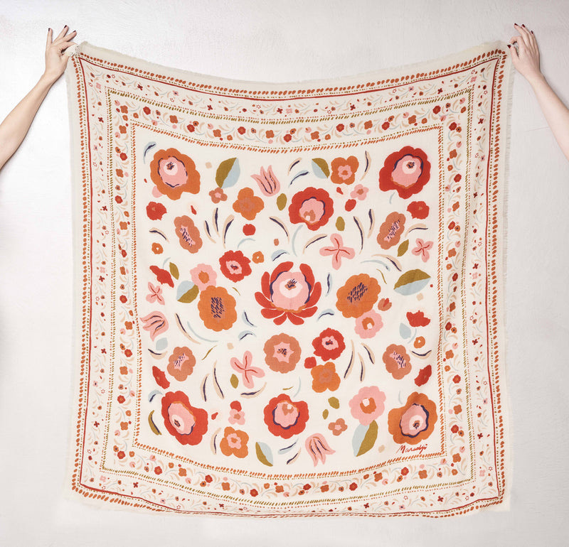 Floral patterned scarf held up against a white background