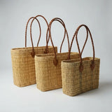 Reed basket with long leather handles